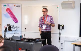 A man speaking to an audience at work