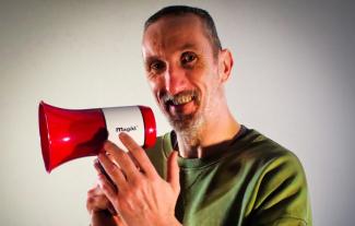 A man holding a megaphone and smiling