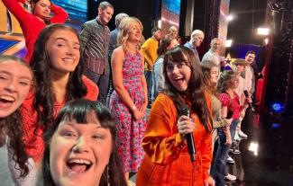 A group of people on a stage, taking a selfie