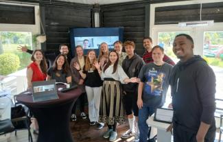 A group of people standing together in a room and smiling