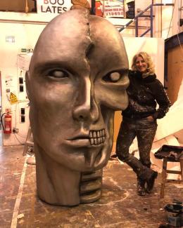 A woman standing next to a sculpture