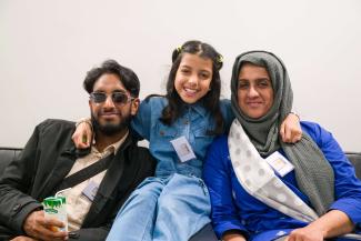 A father and mother smiling, with their daughter between them