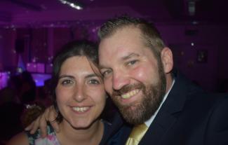 A man and woman with their heads pressed together, smiling