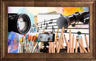 A mixture of creative things, including paintbrushes, coloured pencils, a musical stave, a camera, a notepad, a microphone and a mobile phone