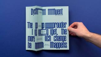 A folder piece of paper with text on it, and a hand holding it