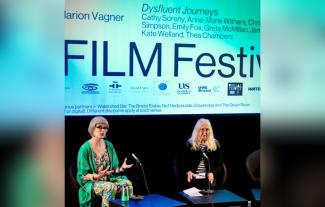 Two women sitting on a stage at a Q&A event, talking