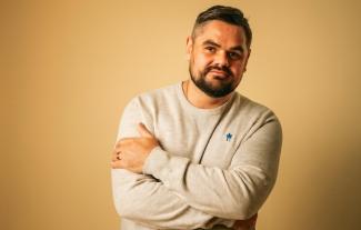 A man with his arms folded, smiling