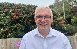 A man in a garden, smiling