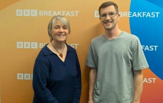 A woman and a young smiling, with 'BBC Breakfast' written on the wall behind them