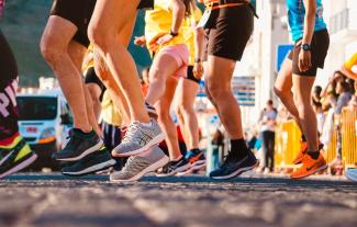 The legs of a group of runners waiting to start a sponsored run