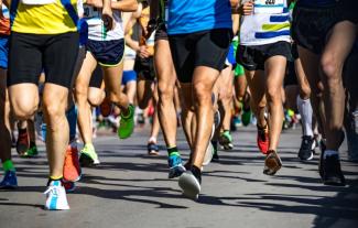 The legs of a crowd of runners at a sponsored run