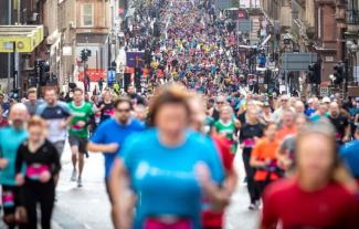 A huge crowd of people running through a street as part of a sponsored run