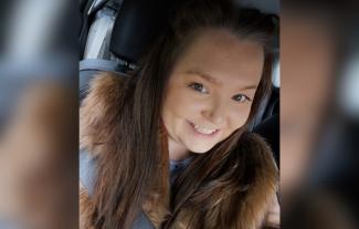 A woman sitting in a car, smiling