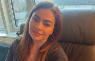 A woman sitting on a chair in front of a window behind her