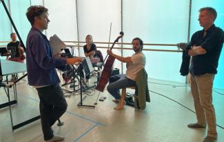 Members of an orchestra rehearsing and chatting