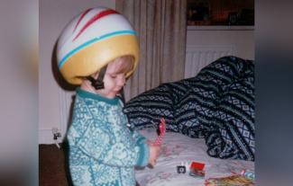 A toddler wearing a crash helmet