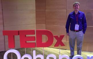 A man standing next to a logo saying 'TED x'