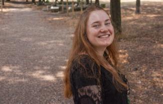 A young woman in a park, smiling