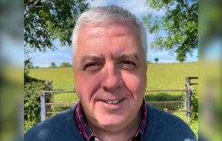 A man in the countryside, smiling