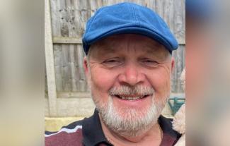 A man wearing a cap and smiling