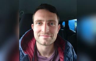 A man sitting in a car and smiling