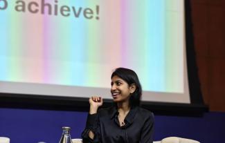 A woman on a stage, smiling