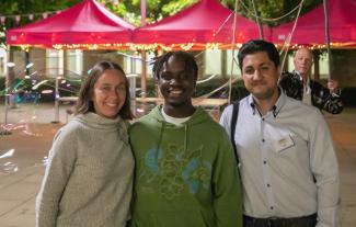 A woman and two men standing side by side and smiling