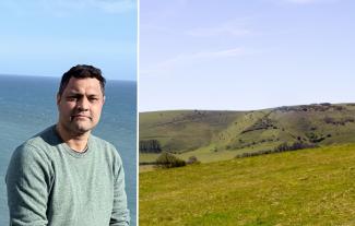 A man with the ocean behind him, next to a field in the Sussex countryside