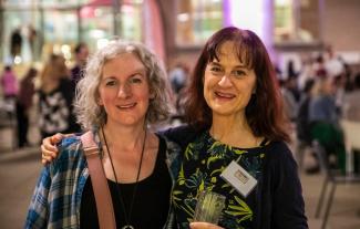 Two women standing next to each other and smiling