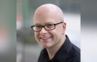 A man in glasses smiling