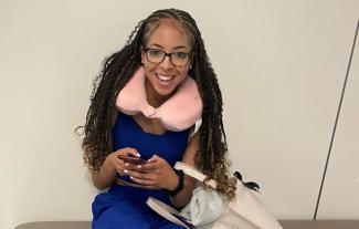 A young woman holding a mobile phone and smiling