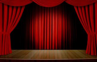 An empty theatre stage, with its curtains open