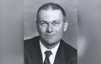 A man in a suit and tie, smiling