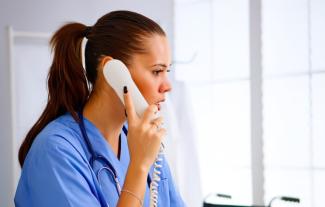 A female nurse speaking into a telephone
