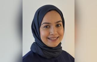 A woman wearing a headscarf, smiling