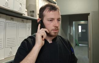 A man speaking into a telephone and looking frustrated
