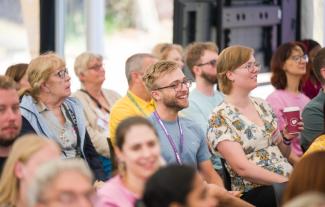 People in an audience, smiling