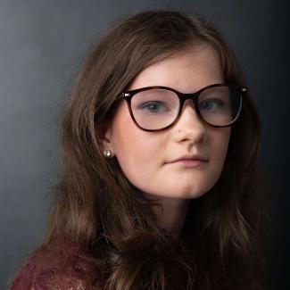 A woman wearing glasses smiling
