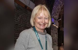 A woman wearing a lanyard and smiling