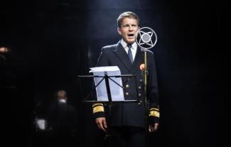 A man on stage speaking into a microphone