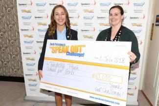 A schoolgirl and a woman holding an out-sized cheque