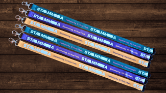 Six coloured lanyards with text on them against a wooden background