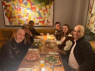 Six people sitting round a restaurant table, smiling for the camera