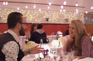 A man and a woman in a restaurant, smiling and talking