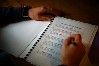 A pair of hands writing on a piece of paper