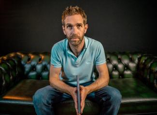 A man sitting on a sofa, holding a book
