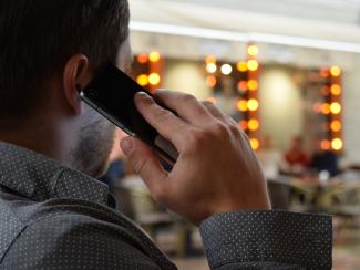 A man speaking on the telephone, seen from behind