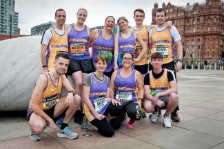 A group of people in running costumes posing for the camera