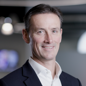A man in a suit smiling