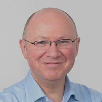 A man wearing glasses and smiling